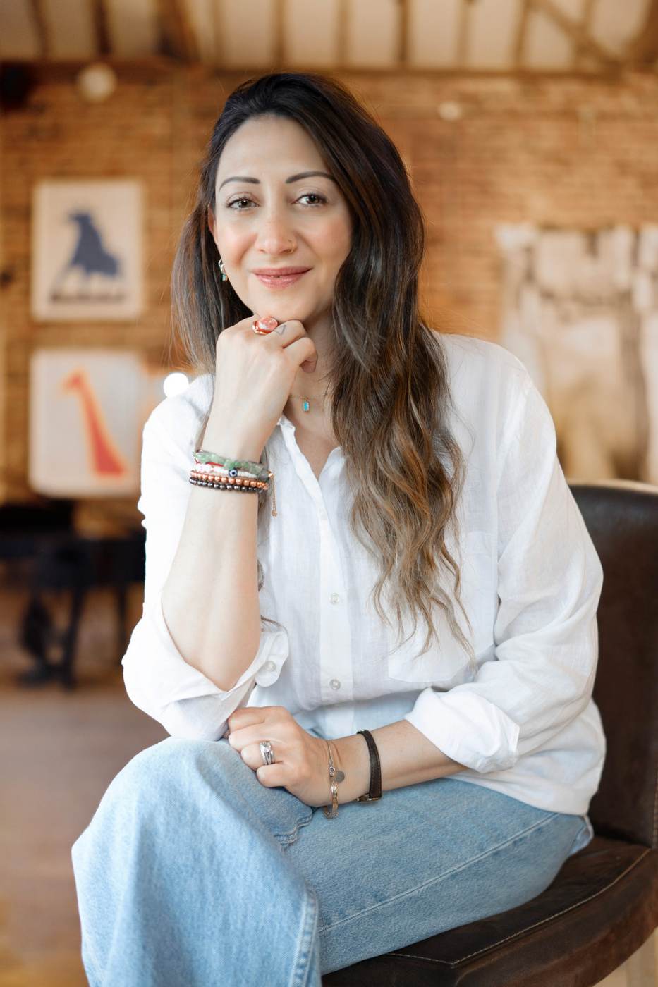 Lauren smiling in a white shirt in her warm studio